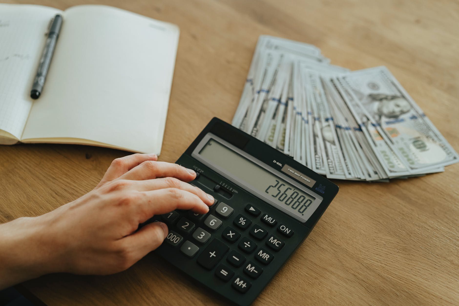 person holding black desk calculator